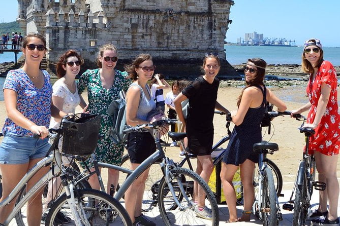 People enjoying a leisurely walk and bike ride along a scenic Lisbon street.