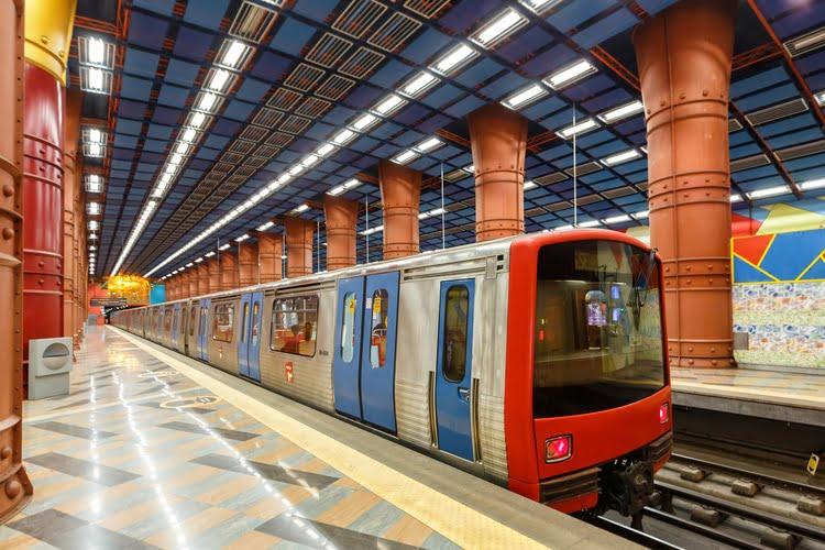 A Lisbon Metro train arriving at a busy station.