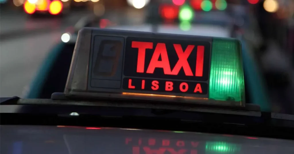 A green taxi waiting outside a famous Lisbon attraction.